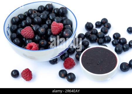 Bols aux baies de saison, mélange de baies fraîches sur fond blanc, bleuets, raisins de Corinthe, framboises. Banque D'Images