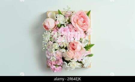 Caisse en bois pleine de couleurs pastel fleurs avec rose rose et carnation sur fond blanc Banque D'Images