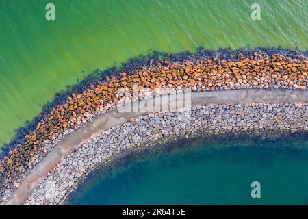 Vue aérienne d'un brise-lames rocheux avec différentes eaux colorées de chaque côté à Sandringham à Melbourne, Victoria, Australie. Banque D'Images