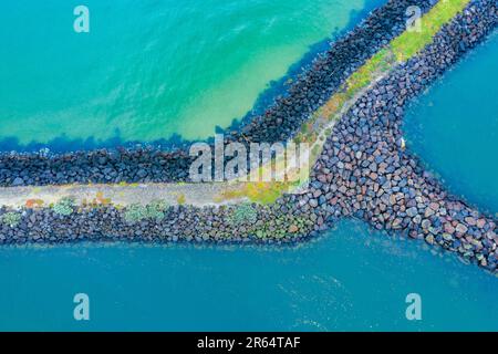 Vue aérienne d'un brise-lames rocheux entouré d'un océan turquoise à St. Kilda Beach à Melbourne, Victoria, Australie. Banque D'Images