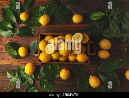 Caisse pleine de citrons avec feuilles, vue de dessus Banque D'Images