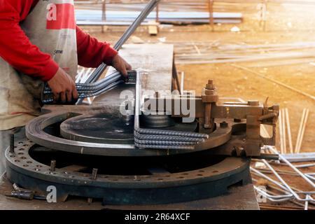 Travailleur utilisant une machine de pliage pour le renforcement sur le chantier Banque D'Images