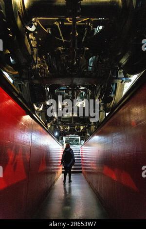 Visiteur marchant sous la locomotive à vapeur C 5/6 2965 de 1915 chemins de fer fédéraux suisses au Musée suisse des transports, Lucerne, Suisse Banque D'Images