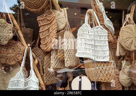 Beaucoup de divers sacs de corde tissés dans une fenêtre de magasin. Divers sacs fourre-tout faits main à vendre dans une boutique d'artisanat traditionnelle Banque D'Images