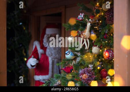 arbre de noël décoré près du père noël. le bokeh doré est magnifiquement décoré et festif pour un nouvel an heureux Banque D'Images