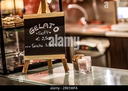 Masi, Italie 7 juin 2023 : une photo en gros plan d'un petit panneau de surveillance affichant les prix de la glace en italien sur un comptoir de bar. Banque D'Images