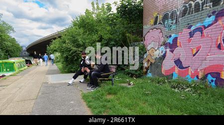 Londres - 05 21 2022 : deux gars boivent de la bière près du pont du A40 sur le canal de Grand Union Banque D'Images