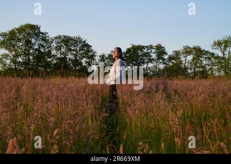 Femme asiatique profitant d'une promenade dans un paysage hollandais au printemps pendant le coucher du soleil Banque D'Images