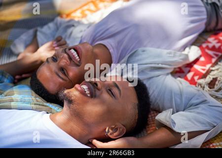 Gros plan couple de jeunes hommes gais heureux et affectueux, allongé sur une couverture Banque D'Images