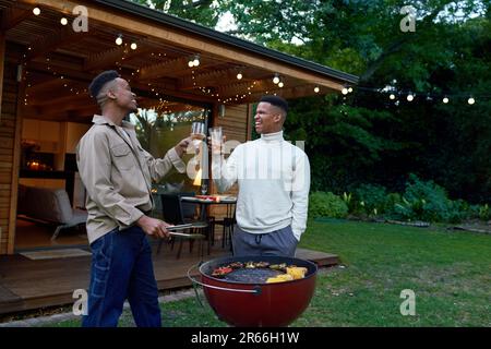 Joyeux jeune gay couple mâle de boire du vin et de barbecue Banque D'Images