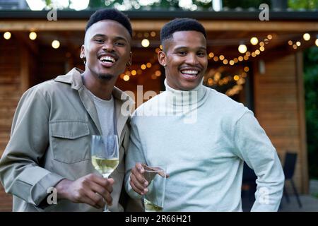 Portrait heureux jeune gay couple homme de boire dans l'arrière-cour Banque D'Images