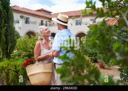 Couple senior heureux et affectueux parlant dans le jardin de la villa Banque D'Images