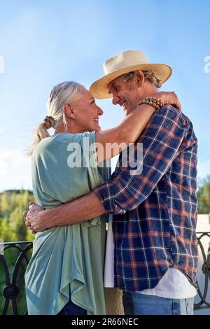 Un couple senior joyeux et affectueux qui s'enserre sur le balcon Banque D'Images