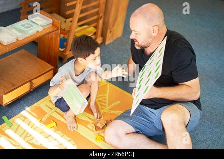 Père enseignant le syndrome de Down à son fils sur les plantes à la maison Banque D'Images