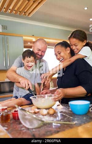 Une famille heureuse qui se fait cuire ensemble dans la cuisine à la maison Banque D'Images