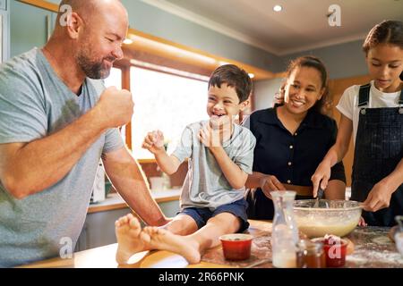 Un garçon heureux avec le syndrome de Down poing heurtant le père dans la cuisine Banque D'Images