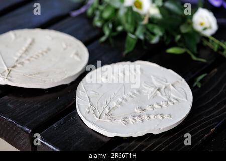 Création de pochoirs en céramique avec fleurs et feuilles de lavande et autres plantes en pressant sur la table Banque D'Images