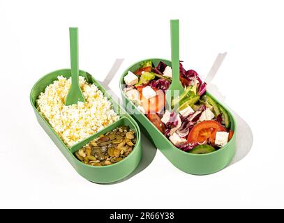 Aliments sains en récipients. Salade de légumes et caillé faits maison avec graines de citrouille dans une boîte à lunch en plastique. Banque D'Images