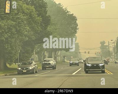 Un ciel voilé, provoqué par des feux de forêt, crée une faible visibilité et des conditions dangereuses et malsaines dans une ville de banlieue Banque D'Images