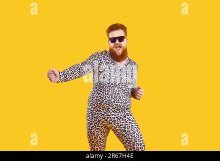 Drôle excentrique balourd homme en pyjama avec imprimé léopard avoir du plaisir, de la danse et de se tromper autour. Banque D'Images