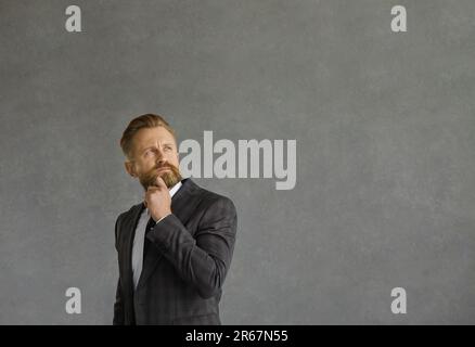 Un homme d'affaires sérieux et attentionné qui regarde par-dessus l'épaule dans un espace de copie de studio vide Banque D'Images