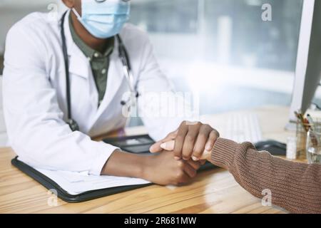 Vous pouvez y parvenir. un médecin méconnaissable assis avec son patient et portant un masque facial tout en la réconfortant dans la clinique. Banque D'Images