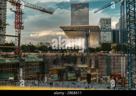Cette prise de vue aérienne illustre un site de construction animé en dessous avec plusieurs grues et des bâtiments en béton partiellement construits en arrière-plan Banque D'Images