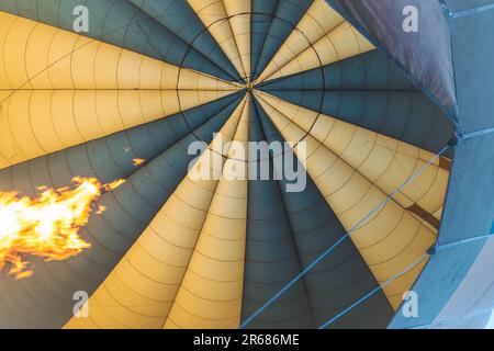 En regardant un ballon d'air chaud alors que l'incendie gonfle le ballon pour flotter Banque D'Images