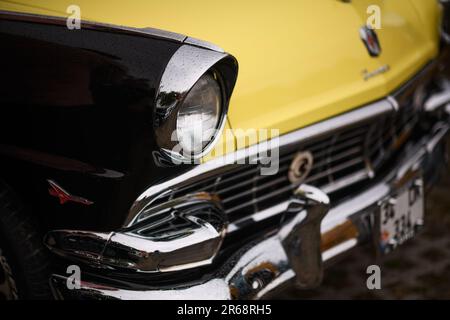 Izmir, Turquie - 3 juin 2023 : gros plan du phare d'une Ford Fairlane jaune et noire de 1956, recouverte de gouttes de pluie, exposé aux Clas IZKOD Banque D'Images