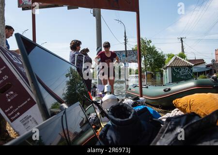 Kherson, Ukraine. 07th juin 2023. Les résidents de Kherson se tiennent sur la rive près d'une pile d'effets sauvés des eaux de crue dans une zone résidentielle de Kherson, en Ukraine, un jour après l'éclatement du barrage de Kakhovka le long de la rivière Dnipro a inondé les communautés sur les deux rives de la rivière au sud du barrage. Des inondations massives ont eu lieu dans les villages le long de la rivière Dnipro à la suite de la destruction du barrage de Kakhovka, en inondant les communautés le long de la rivière au sud et en abaissant les niveaux d'eau dangereusement bas pour les communautés du nord. Crédit : SOPA Images Limited/Alamy Live News Banque D'Images