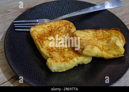 délicieux toast sur une assiette noire et une fourchette Banque D'Images