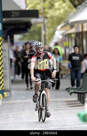 Un service de messagerie à vélo sur Macquarie Street à Queens Square près de Hyde Park à Sydney. Banque D'Images