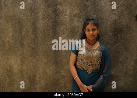 Portrait d'une belle jeune fille adolescente, de nationalité indienne. Sur l'arrière-plan de la paroi de texture avec un espace de copie pour le texte ou le mot. À l'extérieur Banque D'Images