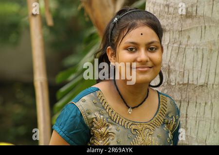 Un jeune magnifique portrait indien adolescente d'expression souriante avec la nature verte extérieure dans le jardin, l'espace de copie. Banque D'Images