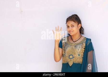 Portrait de la belle adolescente indienne heureuse montrant et pointant avec le doigt numéro cinq tout en souriant confiant et heureux. Banque D'Images