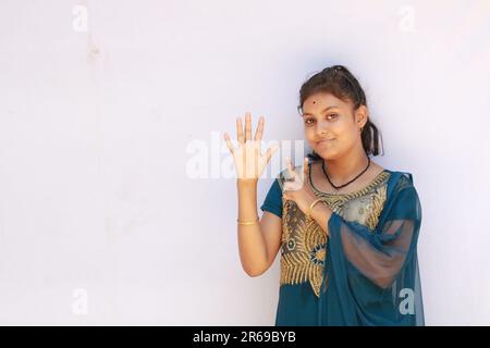 Portrait de la belle adolescente indienne heureuse montrant et pointant avec le doigt numéro sept tout en souriant confiant et heureux. Banque D'Images