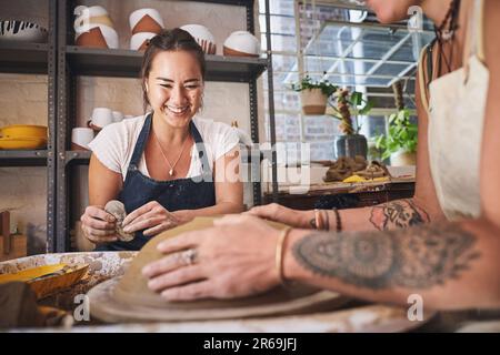 Saisir l'argile avec les deux mains. deux jeunes femmes travaillant avec de l'argile dans un studio de poterie. Banque D'Images