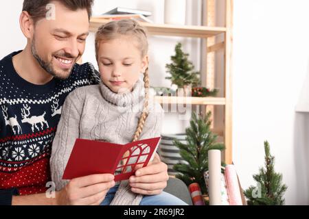 Heureux homme recevant une carte de vœux de sa fille à la maison Banque D'Images