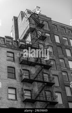 Photo en noir et blanc de l'extérieur d'un bâtiment à Montréal avec évacuation incendie Banque D'Images