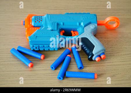 Un pistolet nerf bleu avec des balles sur un parquet Banque D'Images