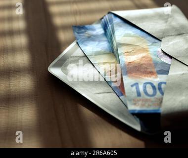 Un tas de billets de banque en franc se dispersant dans une enveloppe sur une surface en bois sous éclairage moody - rendu en 3D Banque D'Images