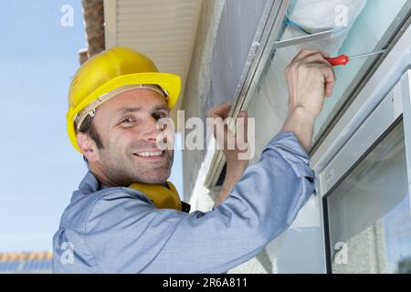 bon entrepreneur en charge de l'installation du tuyau de vidange de la goulotte de descente de gouttière Banque D'Images