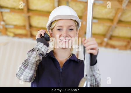 jeune femme constructeur tenant talkie walkie Banque D'Images