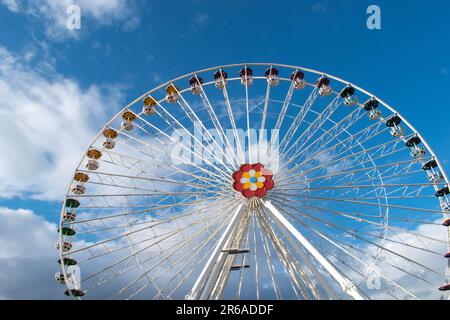 délice d'élévation captivant centre en forme de fleur coloré de la roue de ferris dans le parc d'attractions prater de vienne, au milieu d'une toile sereine de bleu clair Banque D'Images