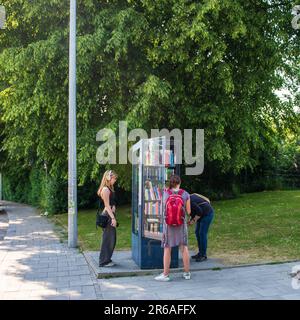 Munich,Allemagne-8 juin,2023: Les gens regardent des livres dans un kiosque d'échange de livres Banque D'Images