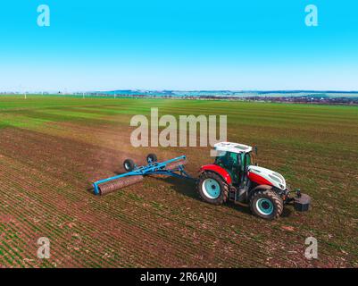 Tracteur en champ agricole. Vue aérienne du tracteur agronomique roulant Banque D'Images