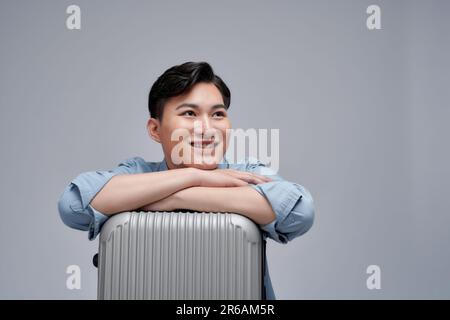 Voyageur heureux homme tenir la valise passeport isolée sur fond blanc Banque D'Images