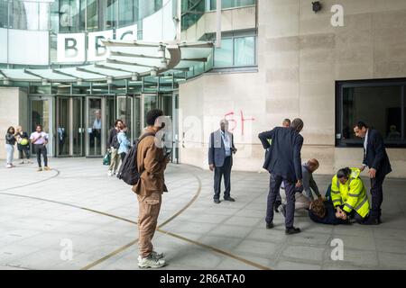 Londres- 23 mai 2023: Un manifestant anti BBC tente de vaporiser quelque chose sur BBC Broadcasting House et est attaqué par la sécurité. Banque D'Images