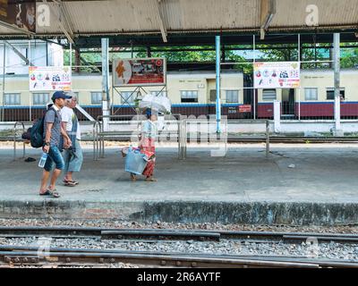 Passagers attendant leurs trains à Yangon Central, la gare principale de Yangon, Myanmar. Banque D'Images