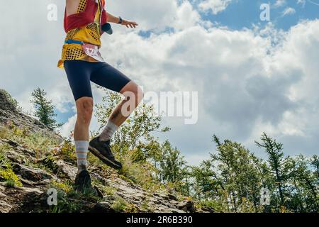 homme coureur équilibrant sur la course de course en pente raide de montagne, course de marathon d'été de piste Banque D'Images